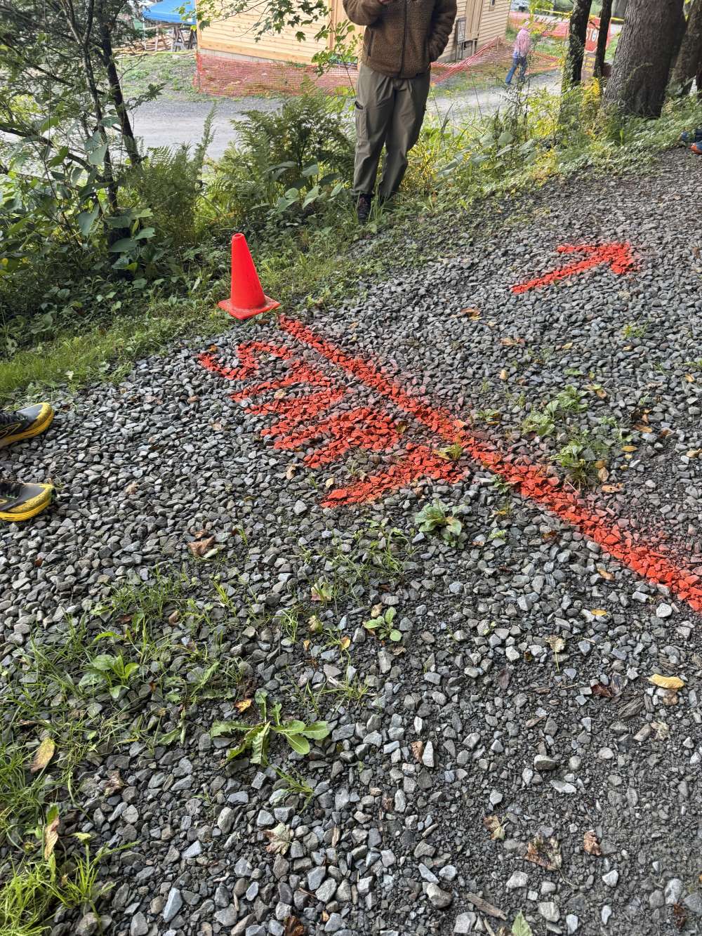 A gravel path with an orange line and the word START spray painted below it.